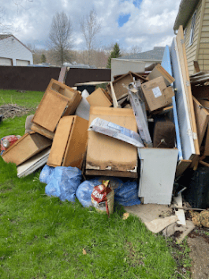 Large backyard junk pile with furniture and debris removed by Pure Disposal junk removal service